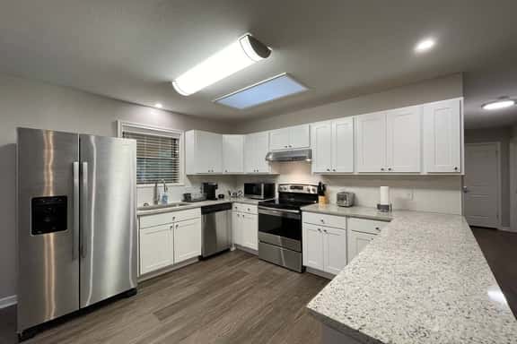Huge kitchen overlooking patio with bar, dining area & open to living room