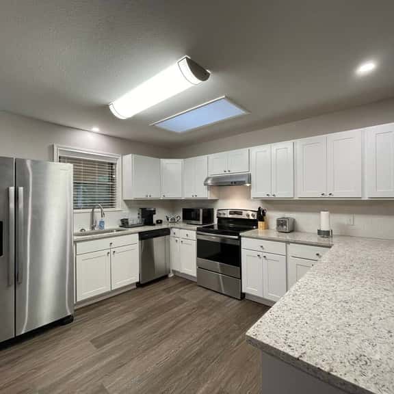 Huge kitchen overlooking patio with bar, dining area & open to living room
