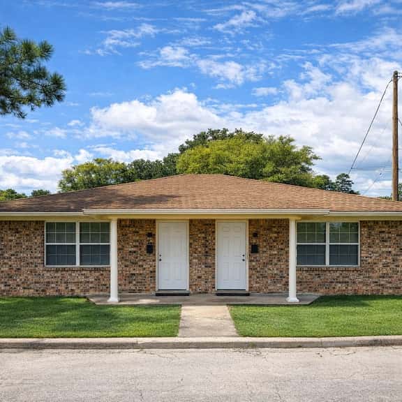 Charming brick duplex with a spacious lawn and welcoming curb appeal