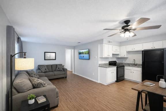Bright open living area with full kitchen and cozy modern seating