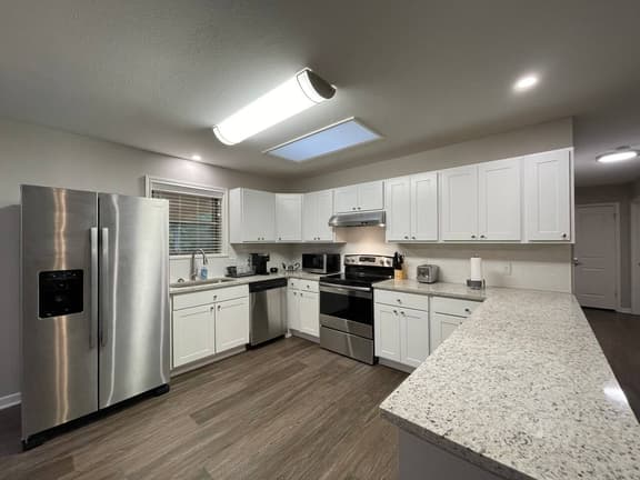 Huge kitchen overlooking patio with bar, dining area & open to living room