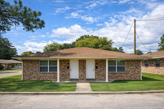 Charming brick duplex with a spacious lawn and welcoming curb appeal